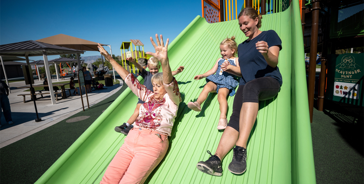 Multigenerational family playing on Mighty Descent slide